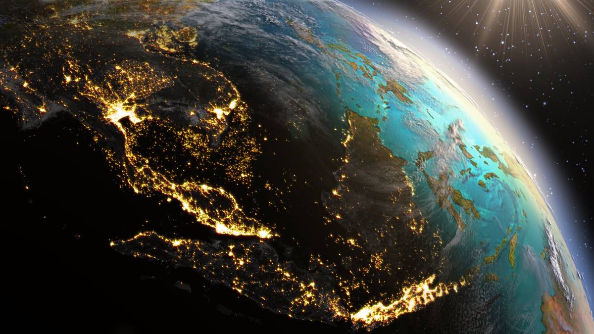A stunning view of Earth from space highlighting Southeast Asia, with city lights glowing brightly against the night side of the planet.