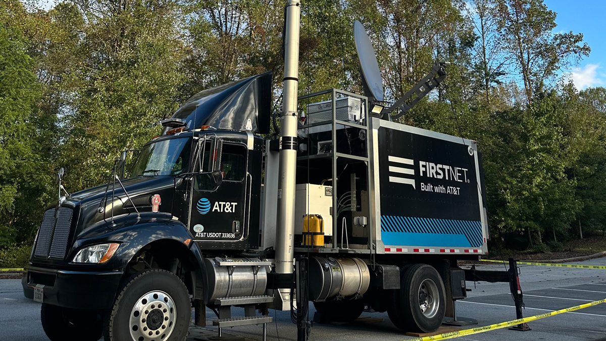 A black AT&T FirstNet response truck with a tall, extended antenna and satellite dish for emergency communications.
