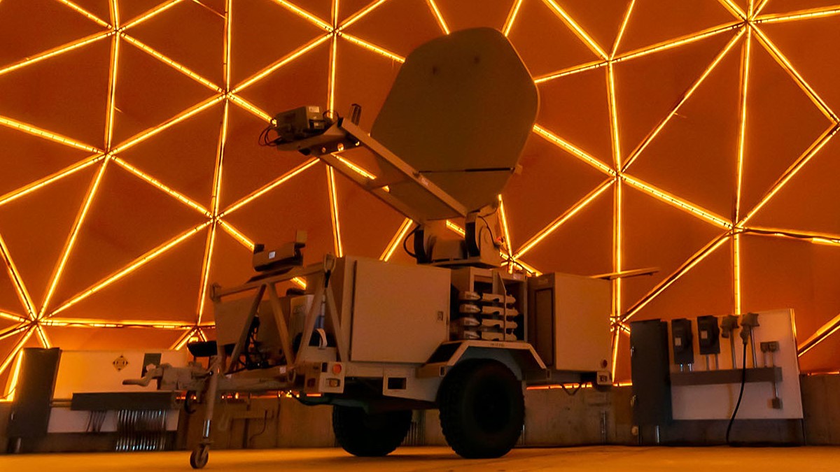 A mobile satellite terminal with dish antenna housed in an illuminated geodesic radome tests AN/TSC-167 Satellite Transportable Terminals at Tobyhanna Army Depot.