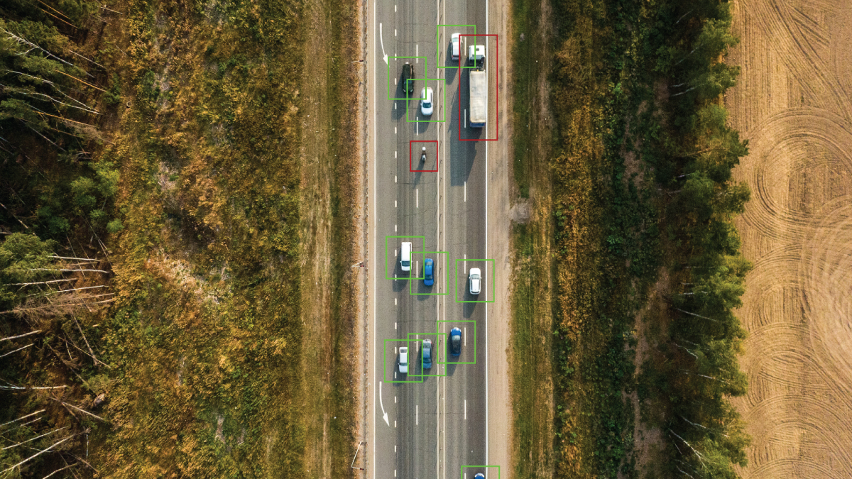 Aerial view of highway with AI-detected vehicles, illustrating IoT-driven traffic analysis and the scale challenges telecom operators face in autonomous systems.