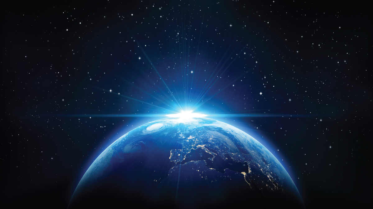 Vibrant Earth from space with city lights and a bright starburst on the horizon.