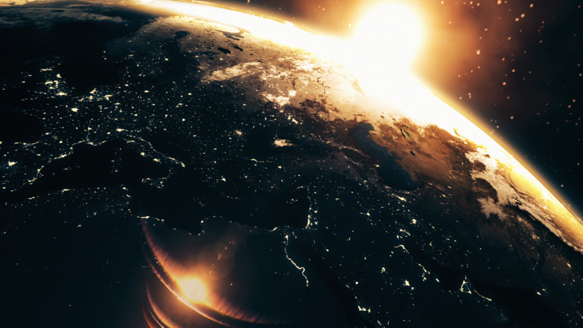 Sunlit view of Earth from orbit at dawn showing Europe, the Middle East and North Africa on the day side and city lights across the night side.