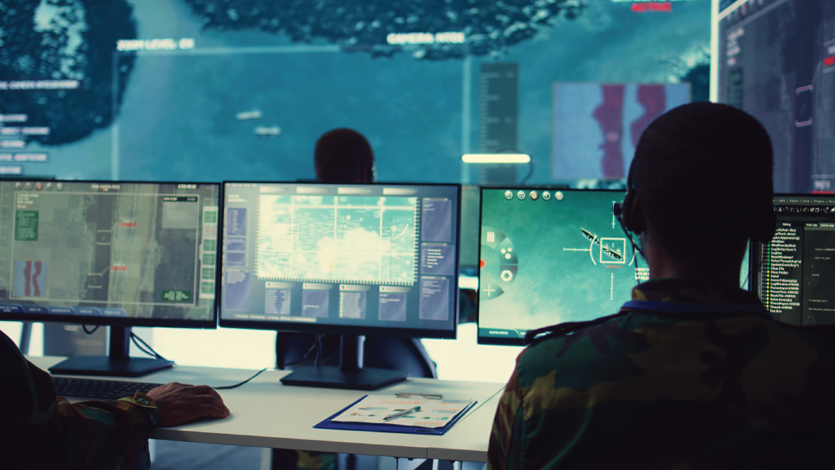 Military command center with personnel monitoring real-time surveillance, satellite imagery, and tactical data on multiple screens during strategic operations.