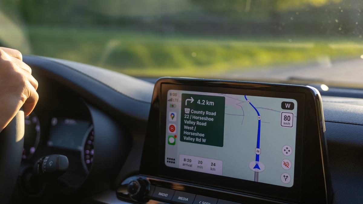A car navigation system in use while a driver is driving on a road.