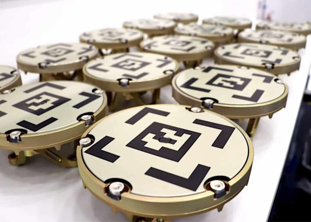 Astroscal's 2nd-generation docking plates, golden docking plates with black geometric designs on them.