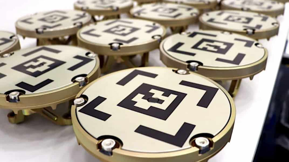 Astroscal's 2nd-generation docking plates, golden docking plates with black geometric designs on them.