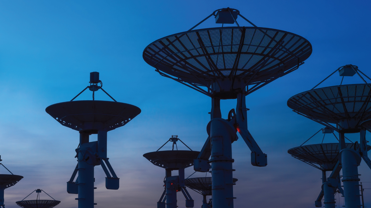 Array of large satellite dishes at twilight, symbolizing geospatial imaging and X-band spectrum usage under review at World Radiocommunication Conference.