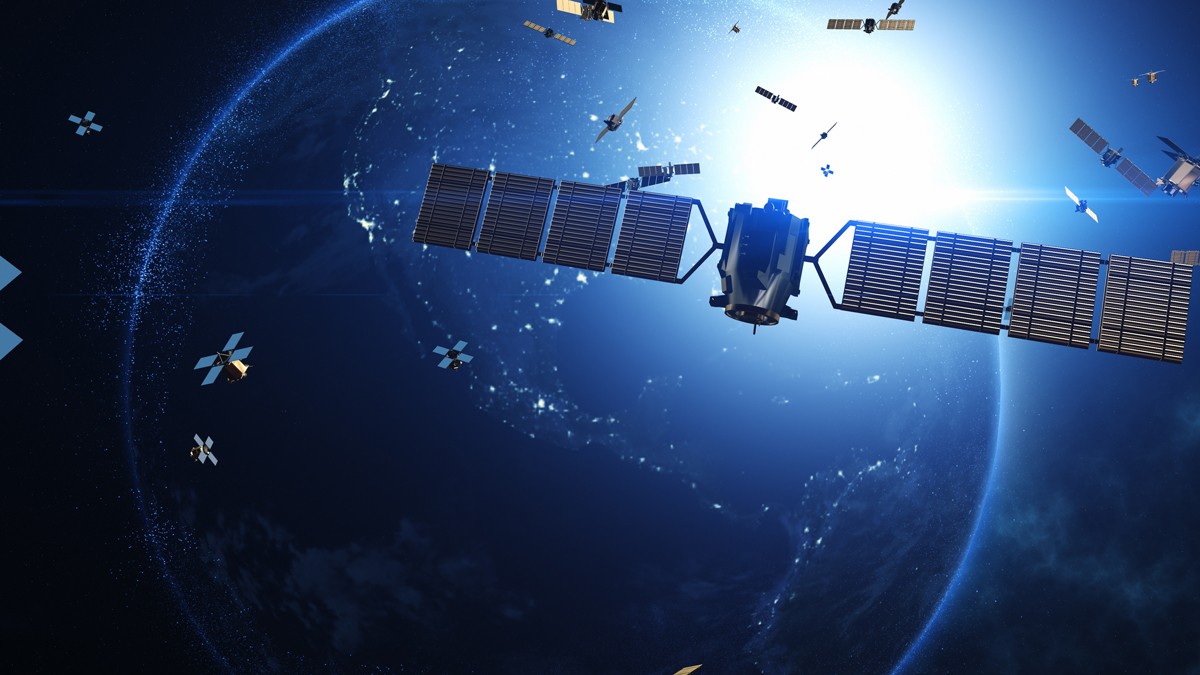 A large satellite and swarm of smaller spacecraft crowd the low Earth orbit above the illuminated planet.