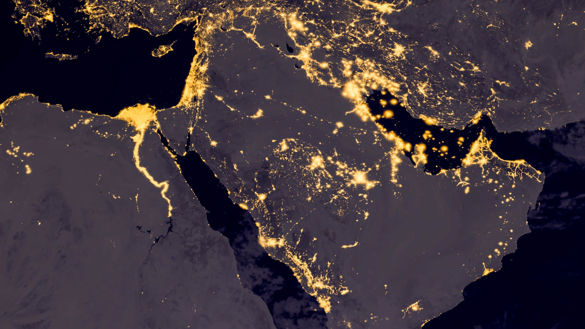 Satellite image of the Middle East at night showing bright golden city lights along the Nile River and Persian Gulf coastlines.