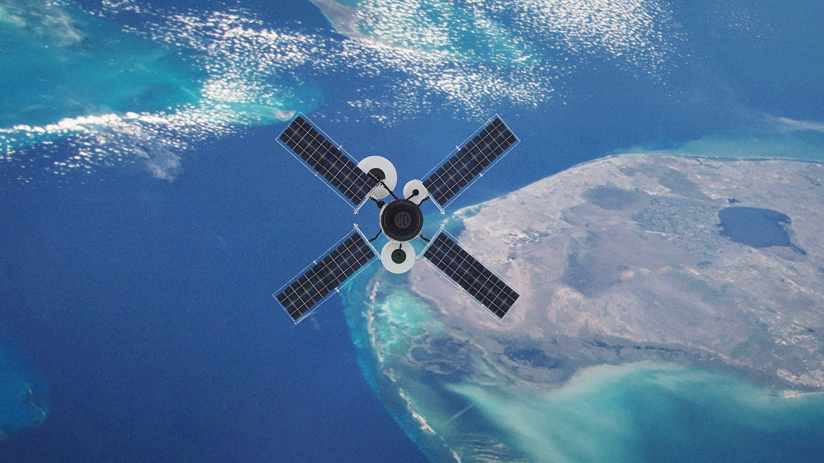 An overhead view of a satellite with four rectangular solar panels arranged in an X-shape, orbiting above the blue waters and coastline of Earth.