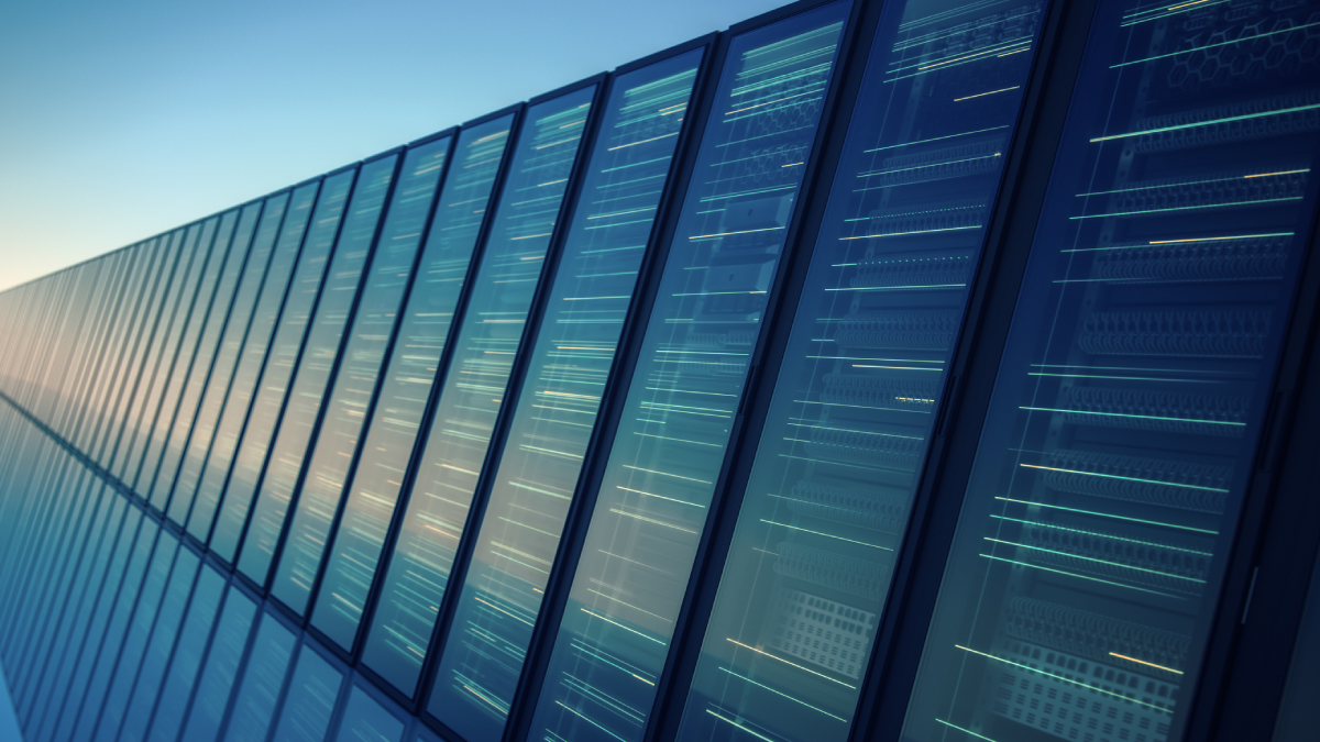 A long row of software-defined server racks with glowing indicator lights extends into the distance under a blue sky, illustrating modern cloud computing and network infrastructure.