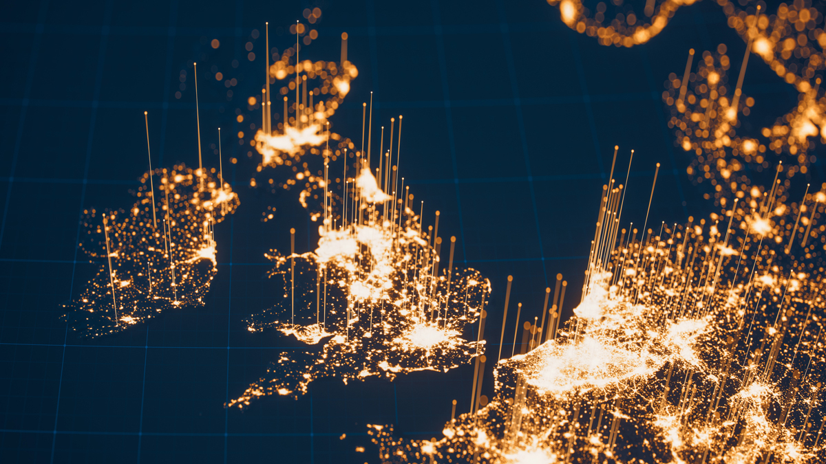 A 3D data visualization map of the United Kingdom and northwestern Europe highlights densely populated regions and urban centers using glowing golden light points and vertical spikes against a dark blue background.