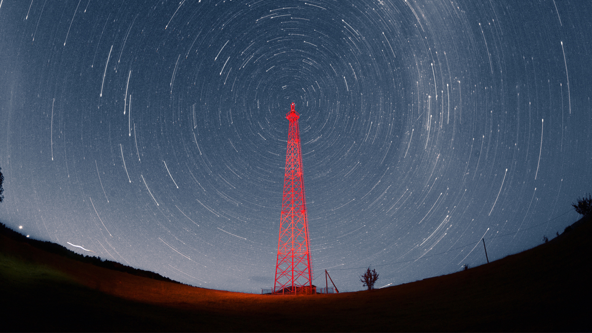 Communications transmission tower surrounded by swirling stars.