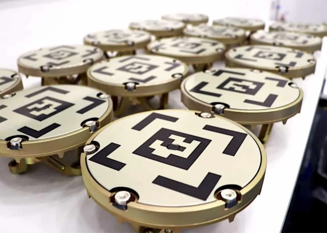 Astroscal's 2nd-generation docking plates, golden docking plates with black geometric designs on them.